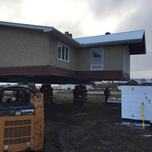 A house on temporary supports ready for foundation work or retro-fitting new technology into older buildings; another McConnell Building Mover service