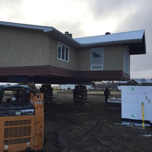 A house on temporary supports ready for foundation work or retro-fitting new technology into older buildings; another McConnell Building Mover service