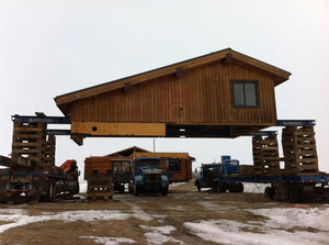 McConnell equipment preparing log house components for transport.